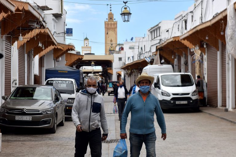 Hommes portant le masque, dans une rue d'une ville marocaine © DR