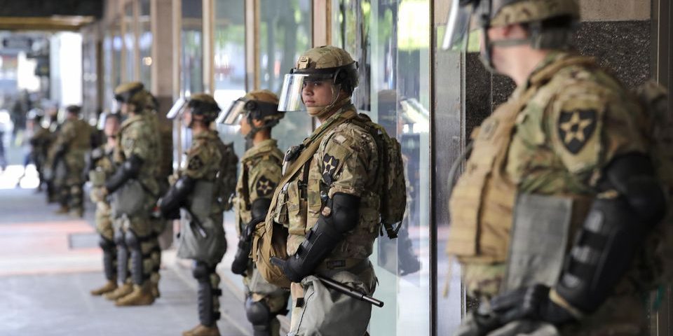 Des soldats non armés de la Garde nationale de Washington montent la garde devant un grand magasin, le lundi 1er juin 2020 à Seattle © Elaine Thompson/AP