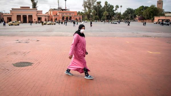 Une femme marocaine portant un masque de protection traverse la place Jemaa el-Fna, presque déserte, dans le centre de Marrakech, le 17 mars 2020. © Fadel Senna, AFP