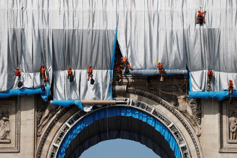 Des cordistes commencent à emballer l’Arc de Triomphe le 12 septembre 2021 © Reuters
